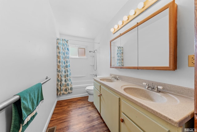 full bath with double vanity, shower / bath combo, a sink, and wood finished floors