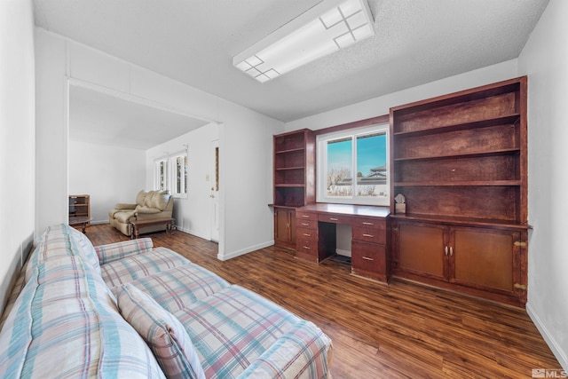 living area featuring dark wood-style floors, built in study area, and baseboards