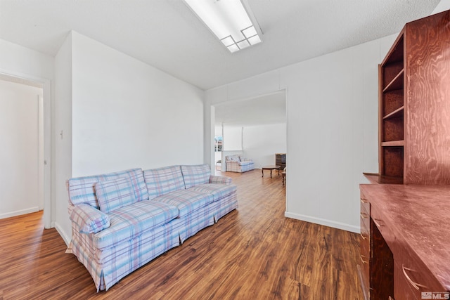 living area with baseboards and wood finished floors