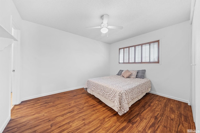 bedroom featuring a textured ceiling, wood finished floors, a ceiling fan, and baseboards