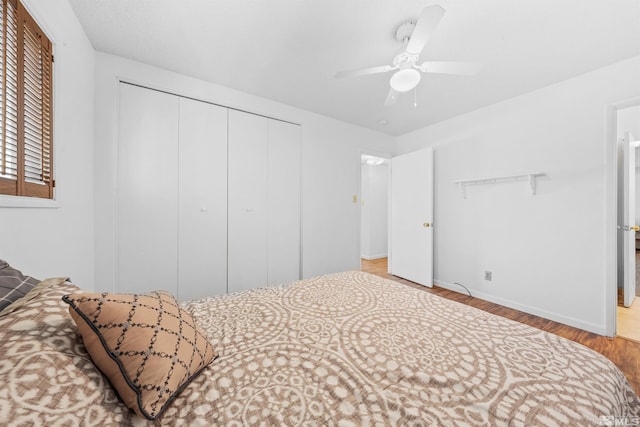 bedroom with ceiling fan, a closet, baseboards, and wood finished floors