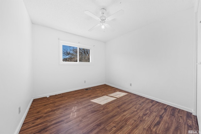 empty room with baseboards, visible vents, ceiling fan, and wood finished floors