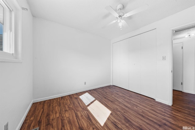 unfurnished bedroom with baseboards, a ceiling fan, wood finished floors, a textured ceiling, and a closet