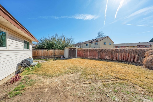 view of yard featuring a storage unit, an outdoor structure, and a fenced backyard