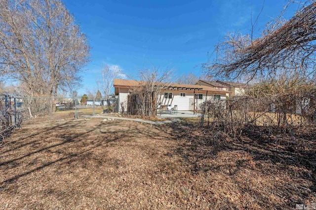 rear view of house featuring a gate, a patio area, and fence