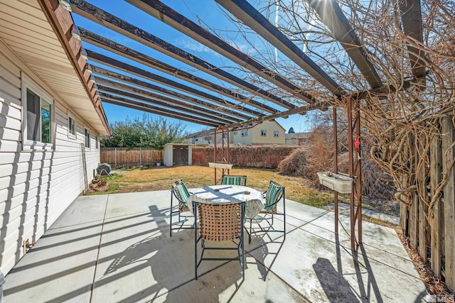 view of patio featuring an outbuilding, a storage shed, outdoor dining space, and a pergola