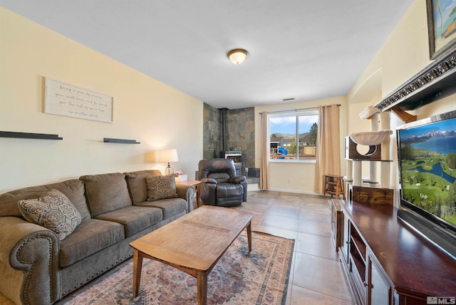 living room with a wood stove and tile patterned floors