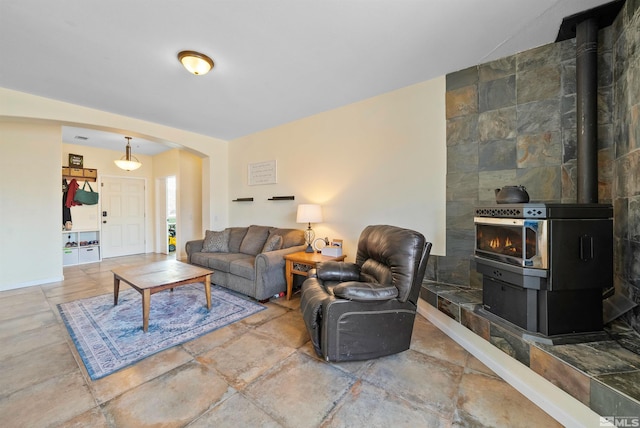 living room with a wood stove and arched walkways