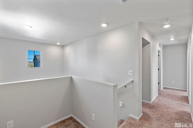 hall with carpet floors, recessed lighting, baseboards, and an upstairs landing