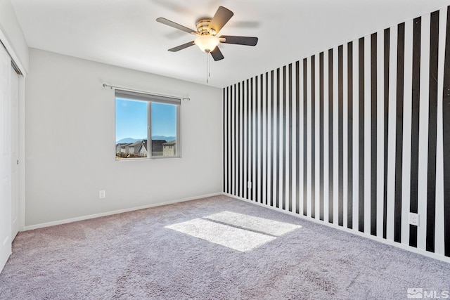 unfurnished room with carpet floors, ceiling fan, and baseboards