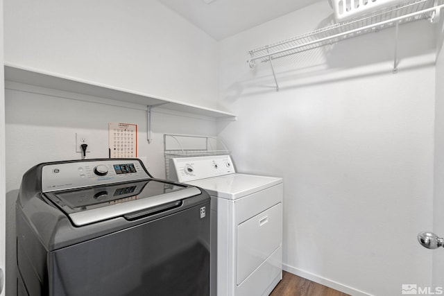 laundry room with laundry area, independent washer and dryer, wood finished floors, and baseboards