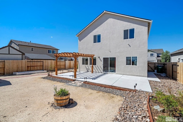 rear view of property featuring stucco siding, a patio area, a fenced backyard, and a pergola