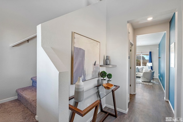 corridor with stairs, wood finished floors, and baseboards