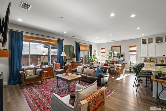 living room featuring recessed lighting, dark wood-style flooring, visible vents, and baseboards