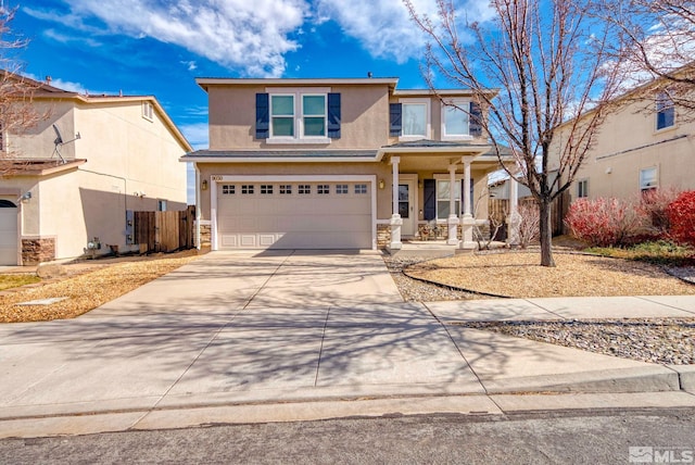 traditional-style home with driveway, a garage, fence, and stucco siding