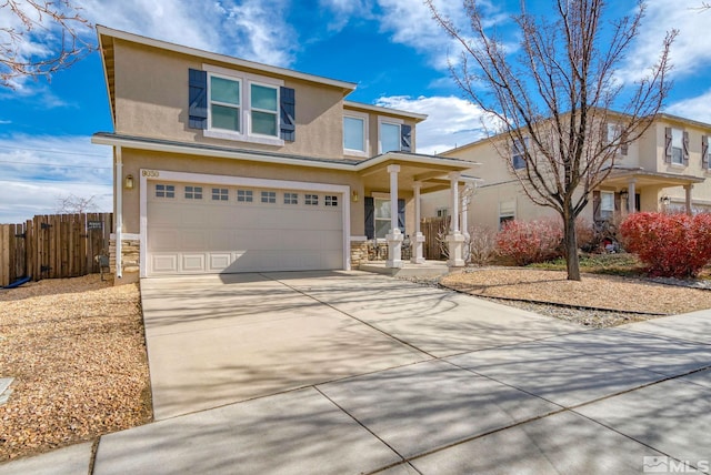 traditional home with concrete driveway, fence, an attached garage, and stucco siding