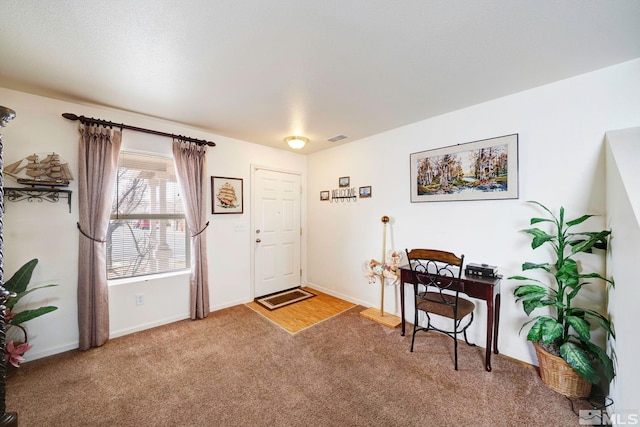 carpeted foyer entrance with visible vents and baseboards