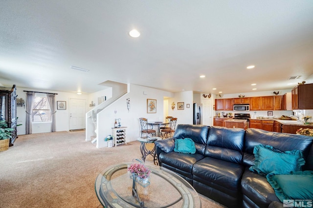 living area featuring stairs, light carpet, visible vents, and recessed lighting