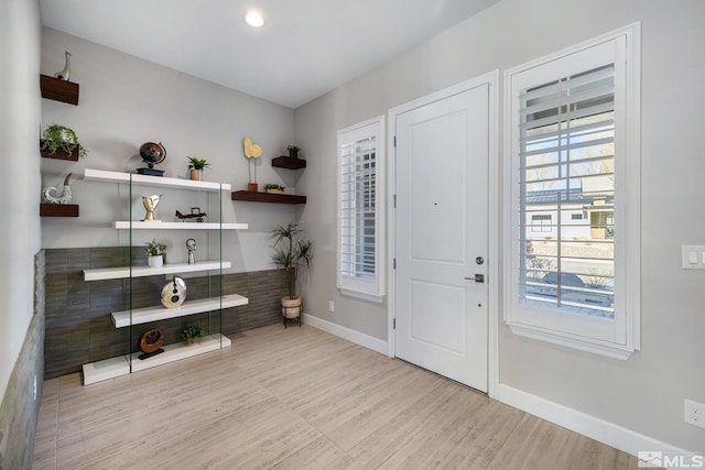 foyer with baseboards and wood finished floors