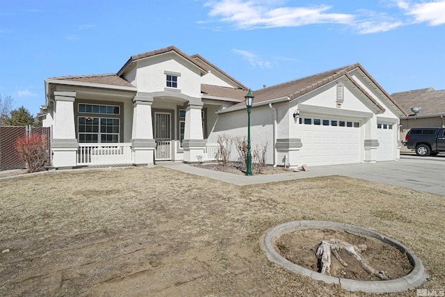 view of front facade featuring driveway, a tiled roof, an attached garage, covered porch, and stucco siding