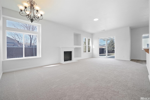 unfurnished living room with a healthy amount of sunlight, carpet, and a fireplace with flush hearth