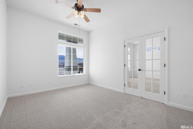 unfurnished room with carpet floors, baseboards, visible vents, and french doors