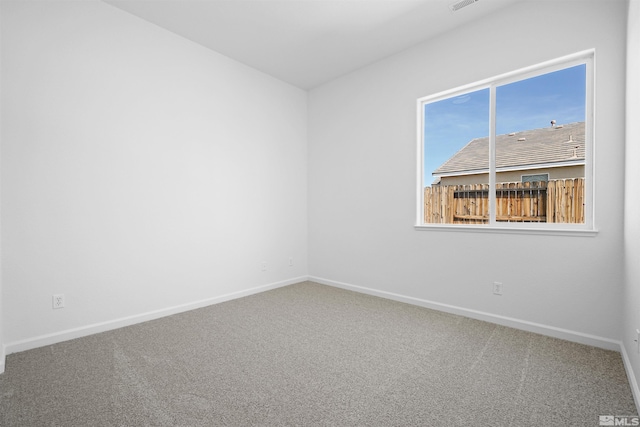 carpeted empty room with visible vents and baseboards