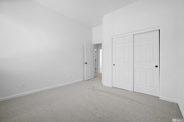 unfurnished bedroom featuring carpet, a closet, and baseboards