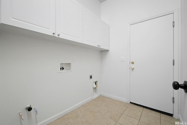 clothes washing area with light tile patterned floors, hookup for a washing machine, hookup for an electric dryer, baseboards, and cabinet space