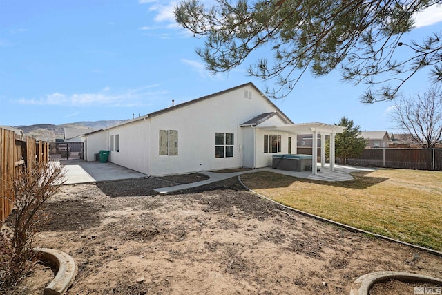 rear view of house with a patio, a fenced backyard, a pergola, stucco siding, and a hot tub