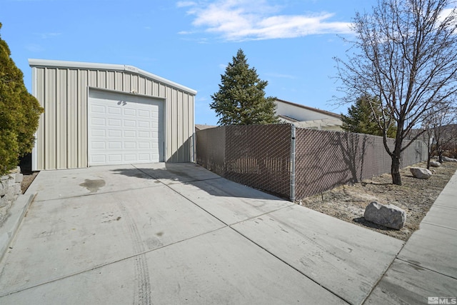 detached garage with fence and concrete driveway