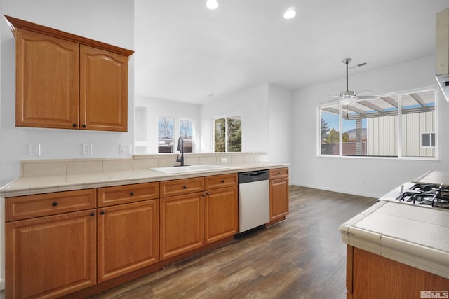 kitchen featuring ceiling fan, dark wood-type flooring, a peninsula, stainless steel dishwasher, and a sink