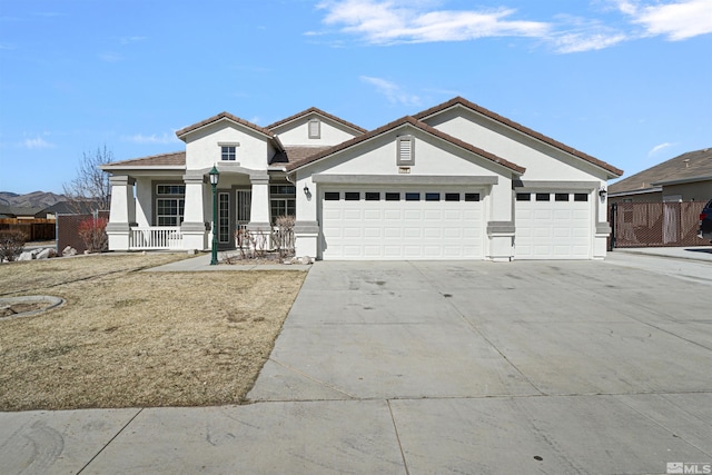 view of front of home with a garage, covered porch, a tile roof, concrete driveway, and stucco siding