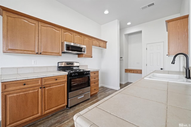 kitchen featuring recessed lighting, dark wood-type flooring, a sink, visible vents, and appliances with stainless steel finishes