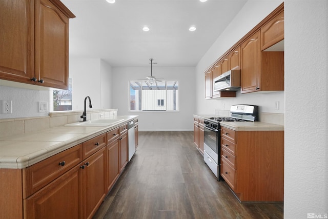 kitchen with tile countertops, appliances with stainless steel finishes, dark wood-type flooring, and a sink