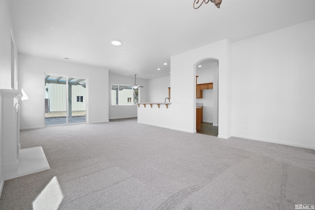 living room with carpet, arched walkways, baseboards, and recessed lighting