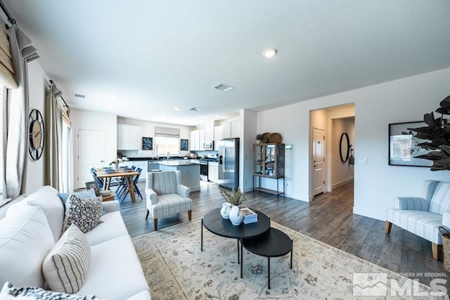 living room featuring dark wood finished floors, visible vents, and recessed lighting