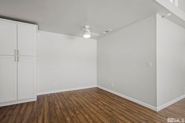 interior space with baseboards, a textured ceiling, visible vents, and wood finished floors