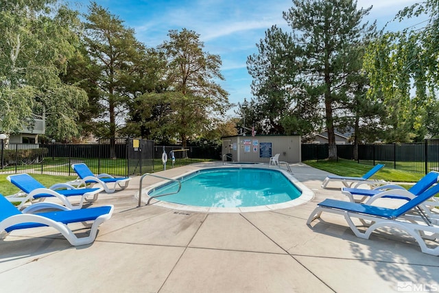 pool featuring a yard, a patio, and fence