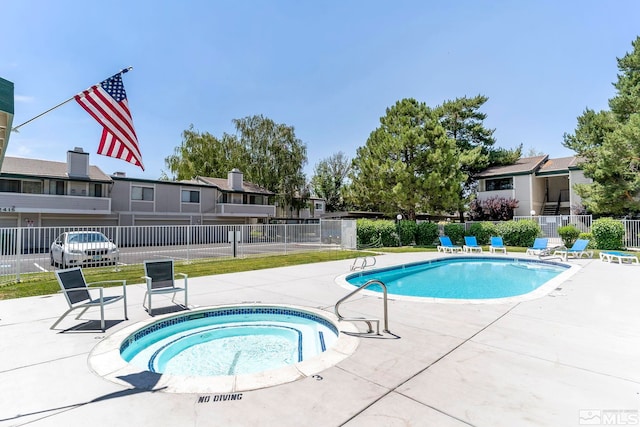 pool featuring a hot tub, fence, and a patio