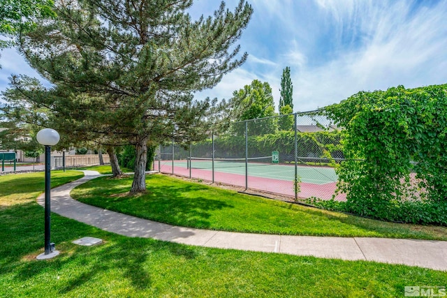 view of sport court with a yard and fence