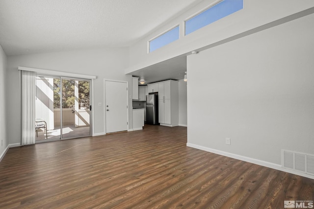 unfurnished living room featuring ceiling fan, high vaulted ceiling, visible vents, baseboards, and dark wood finished floors