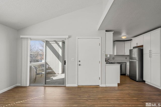 kitchen featuring dark wood finished floors, lofted ceiling, freestanding refrigerator, white cabinetry, and dishwasher