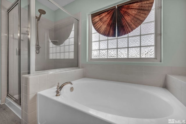 full bathroom with a stall shower and a garden tub