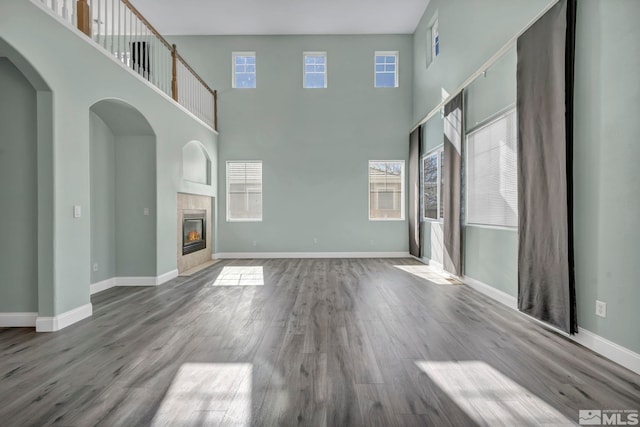 unfurnished living room featuring a wealth of natural light, a fireplace, and wood finished floors