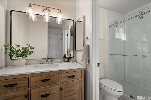 full bathroom with a stall shower, vanity, and toilet