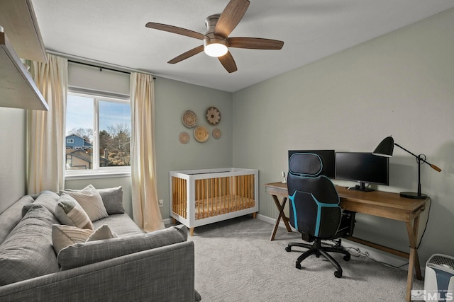 carpeted office with ceiling fan and baseboards