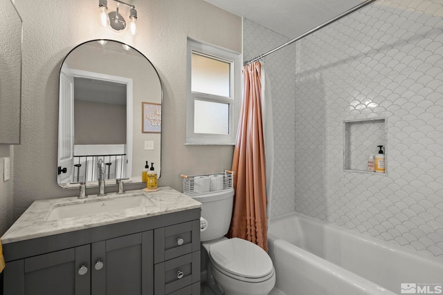 bathroom featuring shower / bath combination with curtain, a textured wall, vanity, and toilet