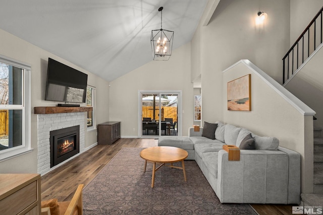 living room featuring a fireplace, stairway, plenty of natural light, and wood finished floors