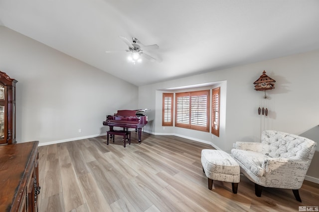 sitting room with baseboards, vaulted ceiling, and wood finished floors